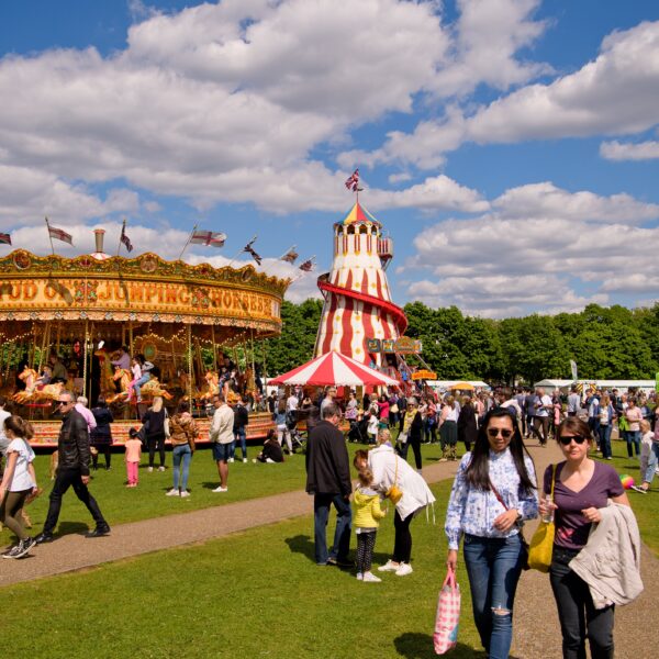 Fairground rides on a green on a sunny day.