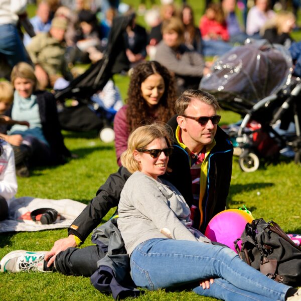 People relaxing on grass in the sunshine.