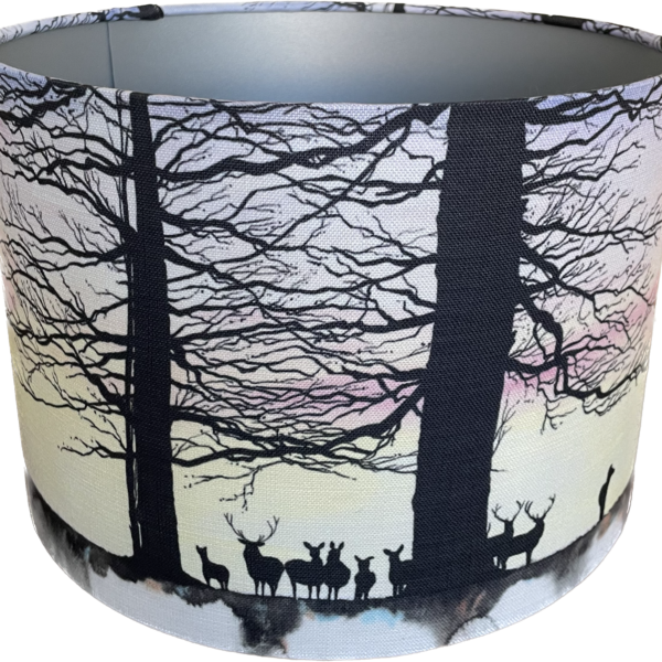a linen lampshade featuring a colourful sky, trees and deer in silhouette