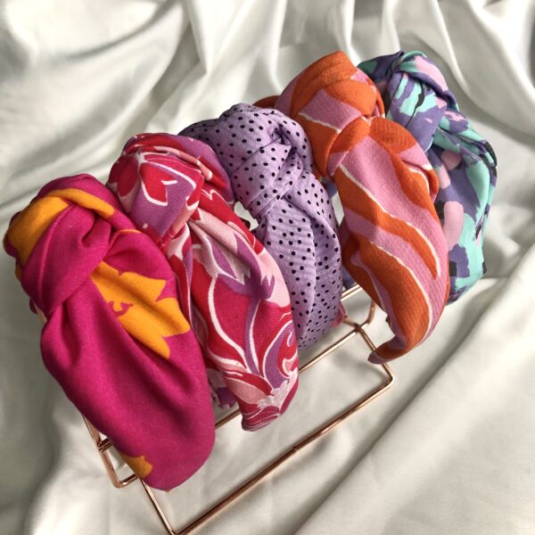 5 headbands with a knot twist in the following fabrics: pink with orange flower, pink and lilac swirl, lilac with black polka dots, orange & pink zebra print, and a 90s abstract in mint, pink & perrywinkle