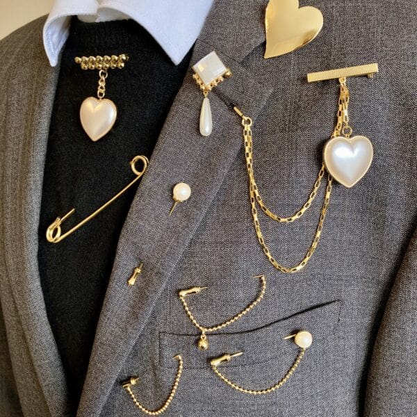 Vintage brooches by Audra's Brooches on a brown jacket - gold and pearl styles of vintage brooches