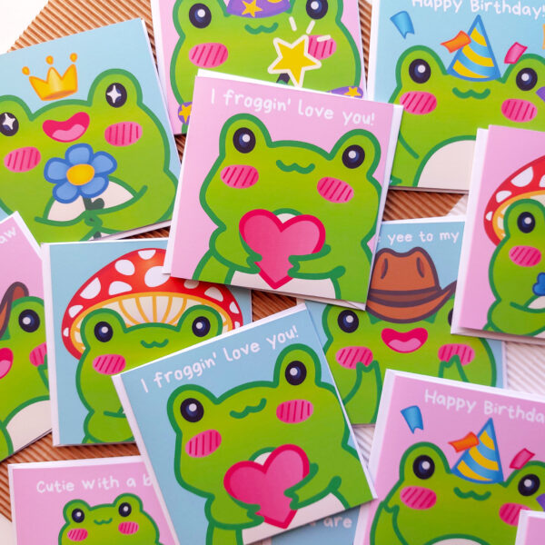Square greeting cards with digital Illustrations of adorable frog characters.