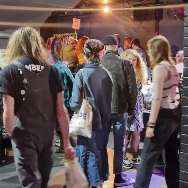 image shows a crowd of people walking through the key club holding shopping bags.
