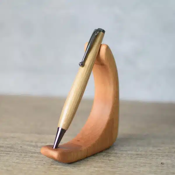 Oak wood turned pen displayed on a curved wooden stand