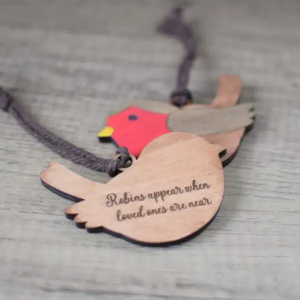 two laser cut robin hanging decorations with laser engraved message on the back