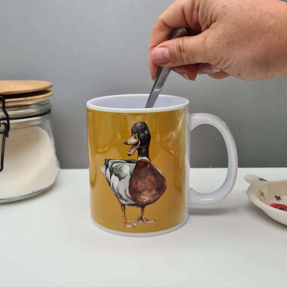A yellow mug featuring a duck print