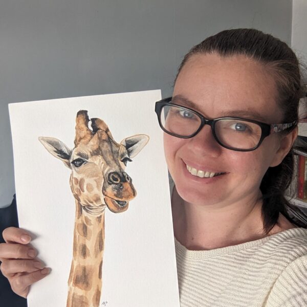 An image of me, the artist, holding up my original art work, Stand tall, a giraffe