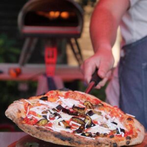 Pizza oven at market food trader stallholder with cooked food