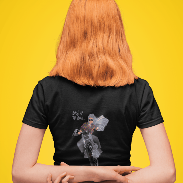 Female wearing a black tshirt with an illustration of a young woman on a motorbike with her hair blowing in the wind and the phrase "Burn Up the Road" and the Stoofy logo.