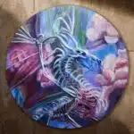 painting of a skeleton dragon surrounded by pink peonies. Painted on a round board.