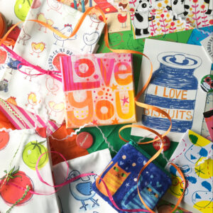 overhead view of various printed products with a small square painting that says Love You