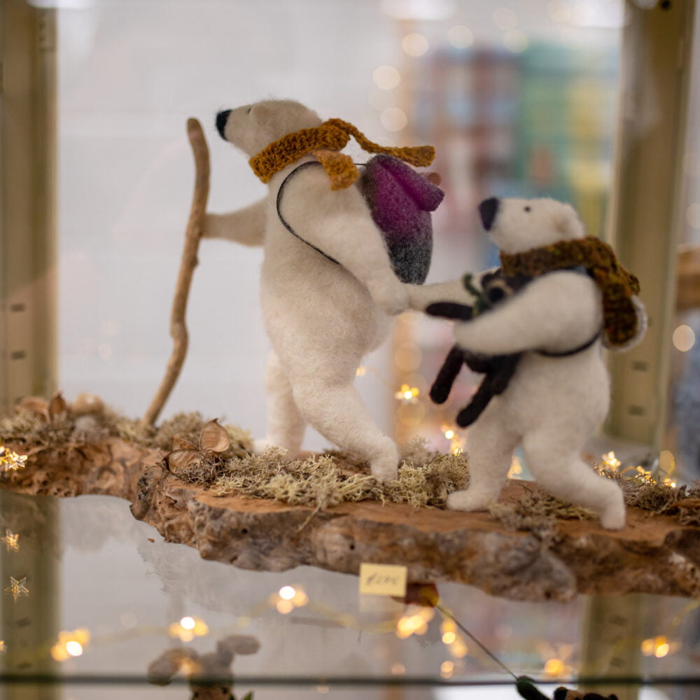 Felt Polar Bear climbing a wooden branch with fairy lights