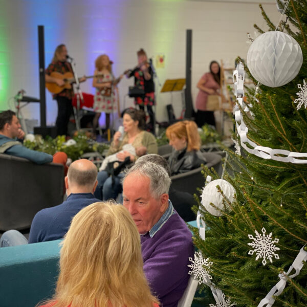 Christmas Tree in foreground with cafe and band playing in the background Makers Cornwall Fair