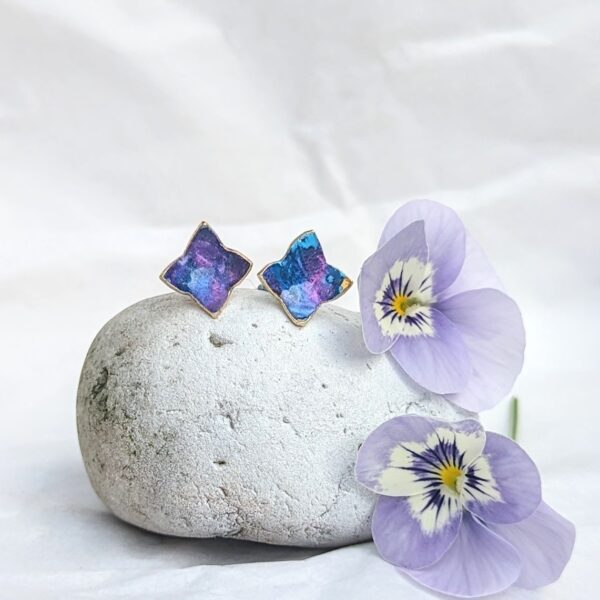 Blue Star studs on display on a peddle with flowers