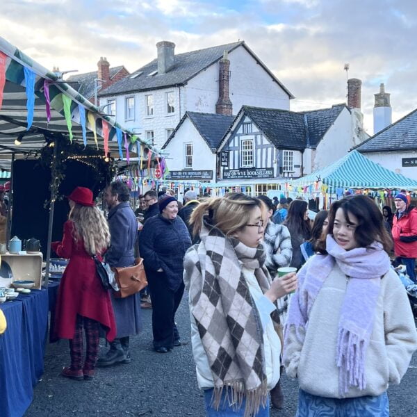 Hay Christmas Fayre, Hay-on-Wye - Photo of shoppers on the market square by stalls at Hay Christmas Fayre 2022