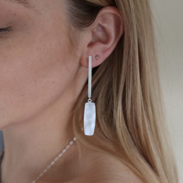 Bethan Corin Long Vessel Drop Earrings Sleek, minimal drop stud earrings with vessel dangle finished with a light catching, almost pearlescent surface, handmade in sterling silver.