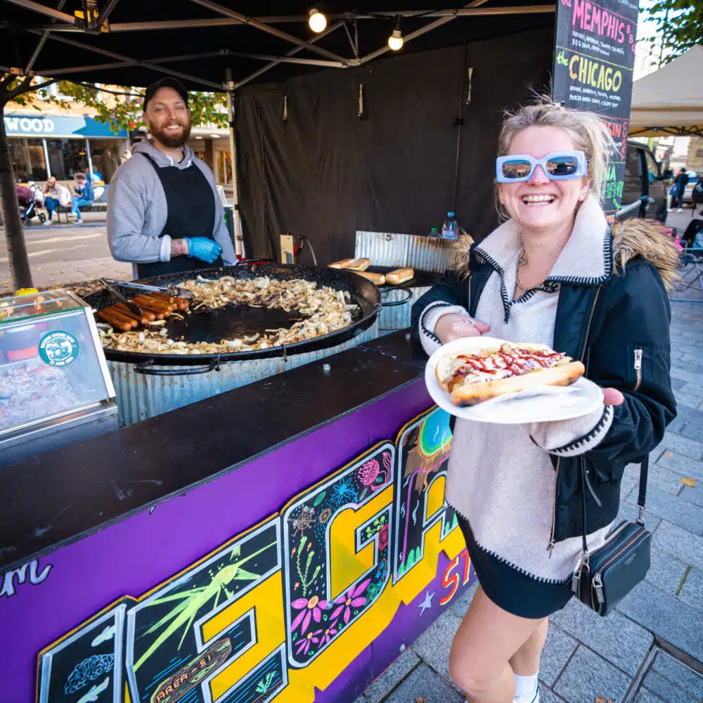 Customer with Hot Dog from Vegan Street Diner at Vegan Market by Vegan Fairs - Carmarthen Vegan Market