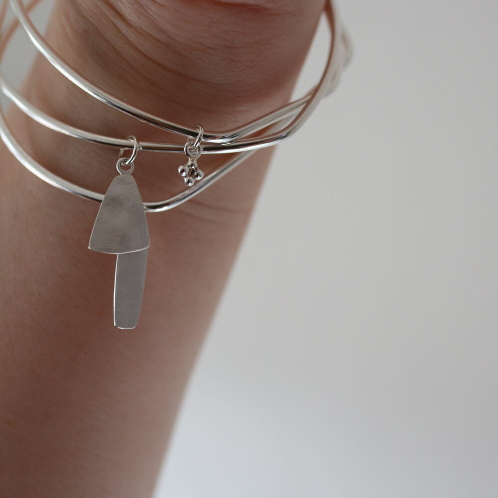Bethan Corin Mangles Unusually and individually shaped bangles with vessle and caterfoil pendants, handmade in sterling silver.