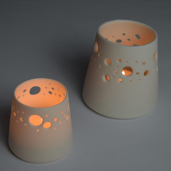 photo shows 2 candle holders with lit tealights burning inside them.