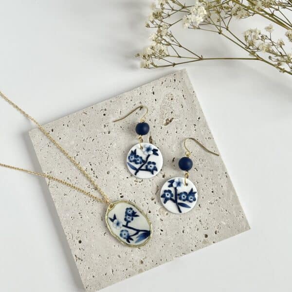 Flat lay of blue and white china round earrings and a blue and white china necklace