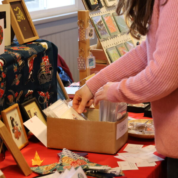 Customer browsing cards on a Japanese inspired stall at Tissington Craft Fair in Derbyshire, Tissington Craft Fairs