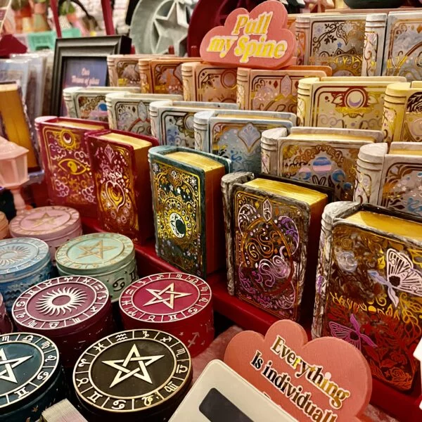 A photo of a display of book shaped jewellery boxes in all colour of the rainbow on tiered shelving