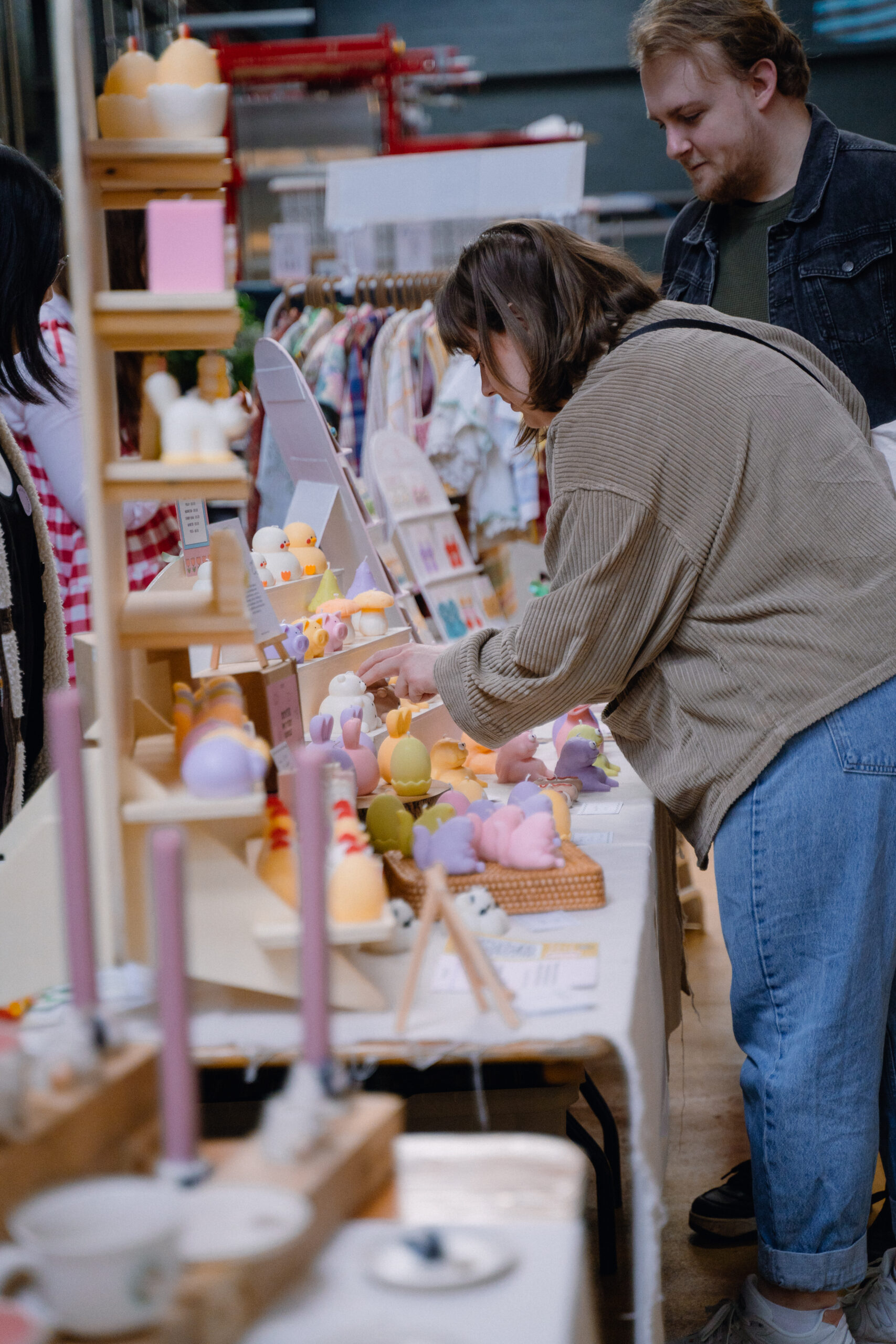 Two customers shopping and browsing a market stall at Mindful Market