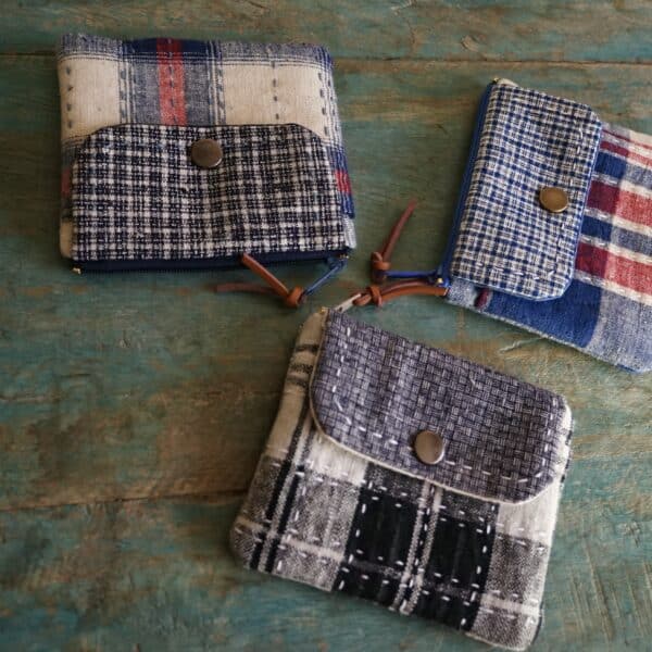 three fabric wallets on the table, all made from vintage fabrics of different patterns and colours