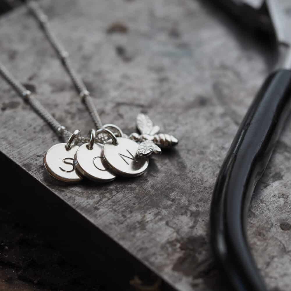 3 silver initial discs on a silver chain necklace