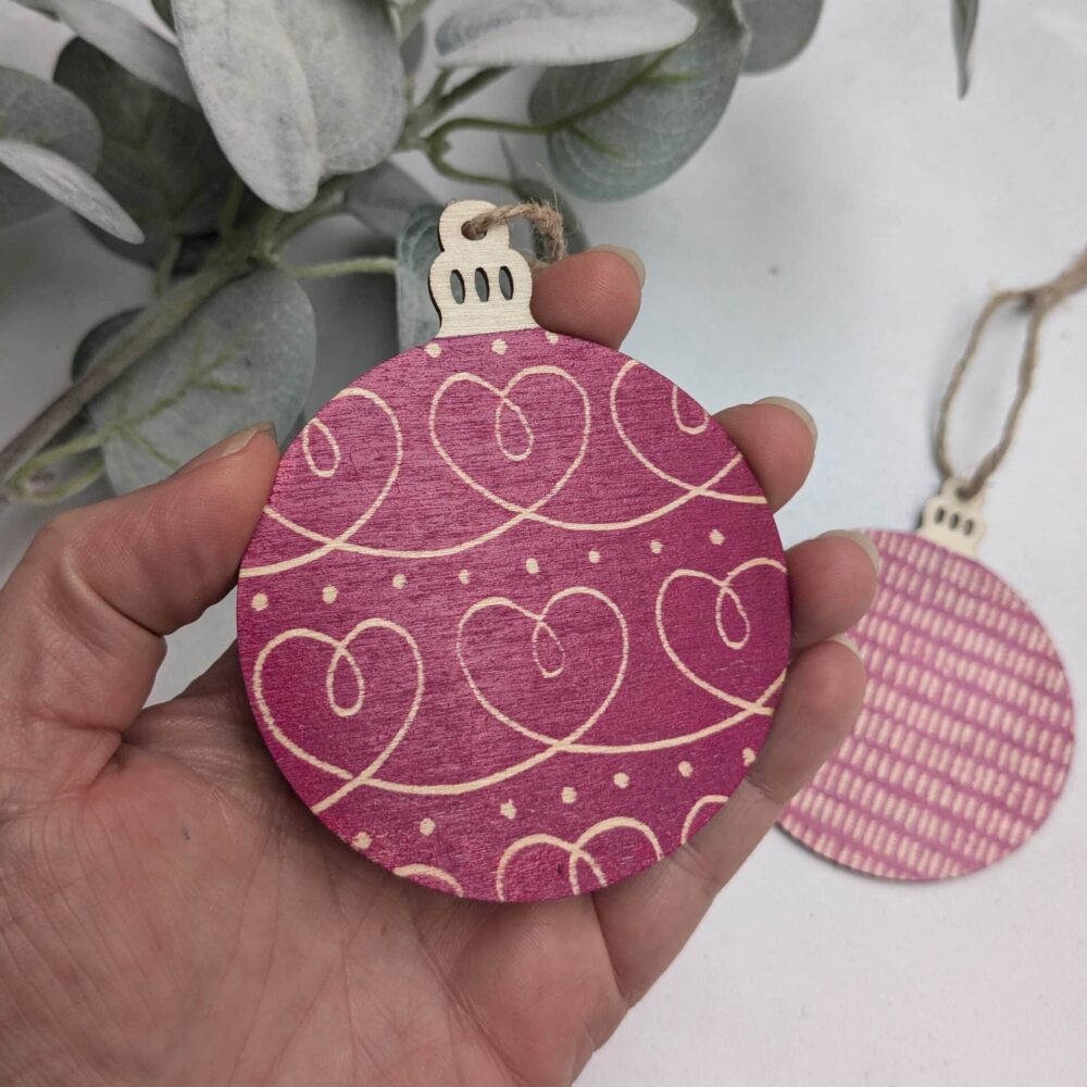 A pink lino printed wooden baubles cutout