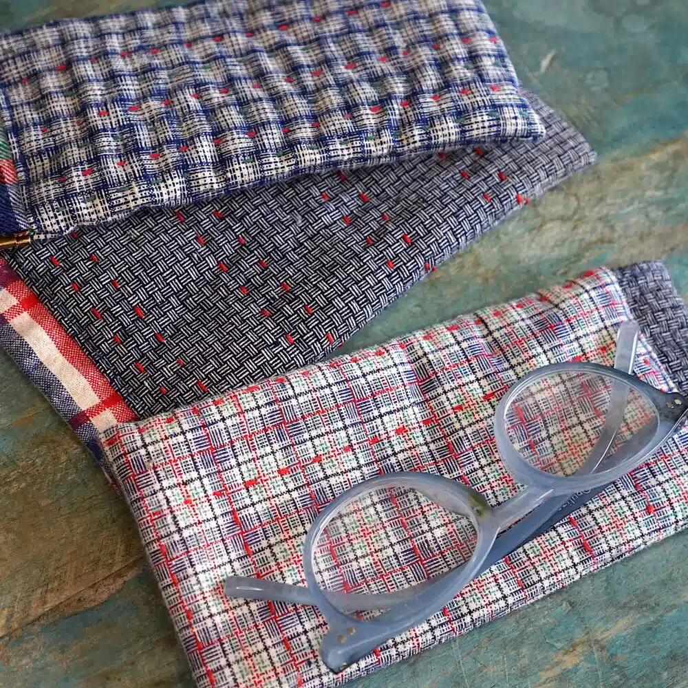 3 fabric glasses cases and a pair of reading glasses