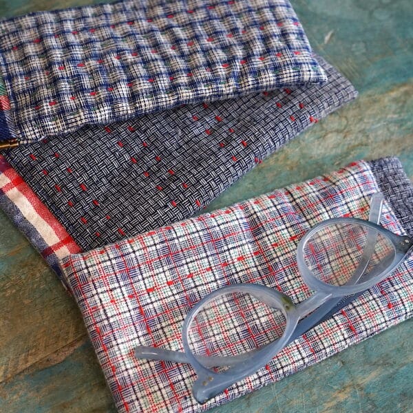 3 fabric glasses cases and a pair of reading glasses