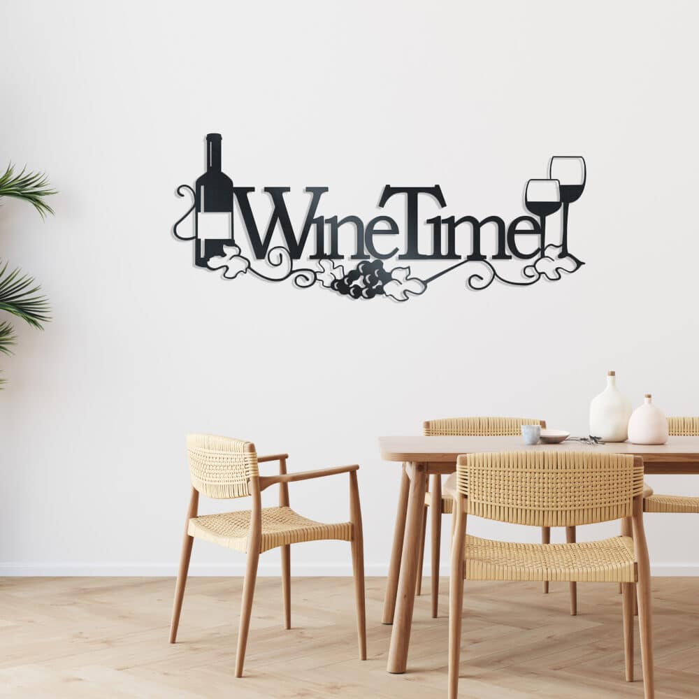 Black metal wall art featuring the words “Wine Time” with a wine bottle replacing the letter “I,” two wine glasses, grapevine accents, and grape clusters, displayed above a light wood dining table in a bright, modern dining room or kitchen.