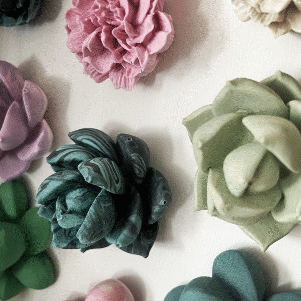 Pink and green roses made from Jesmonite hanging on a wall