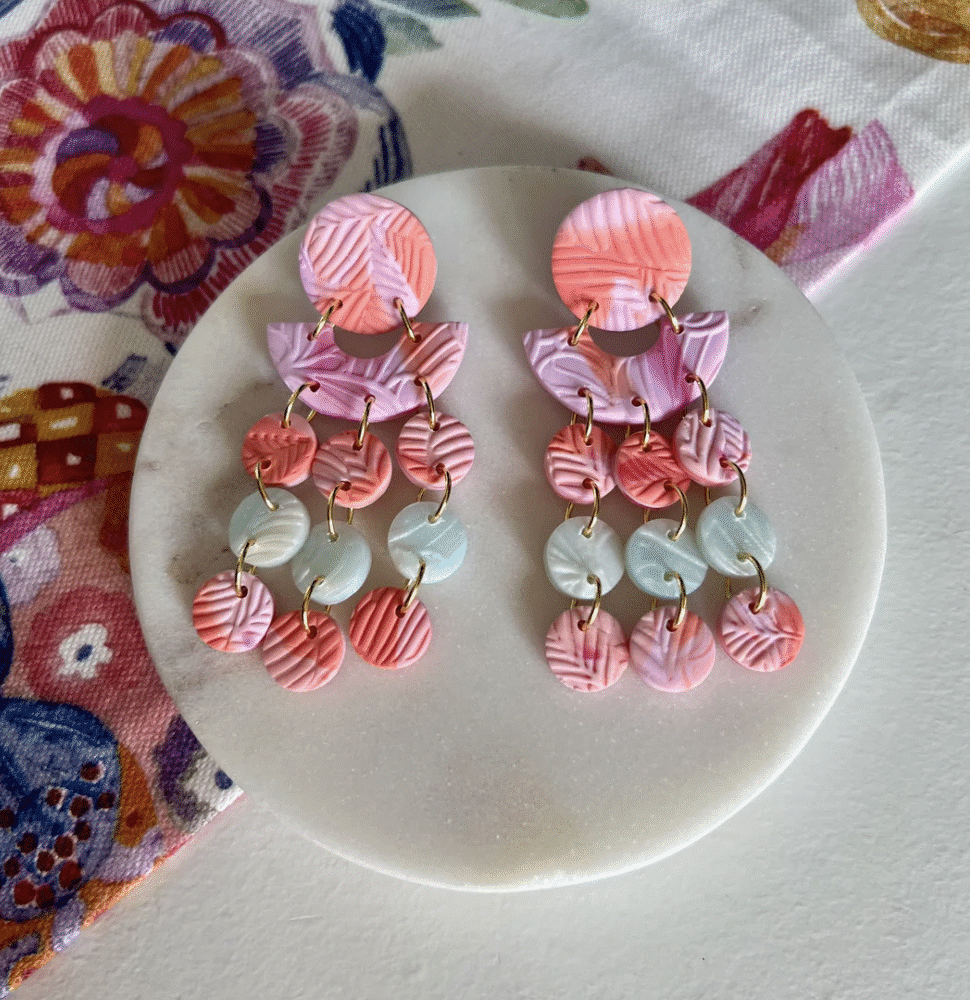 A pair of dangly earrings in sorbet pink and green colours made into discs