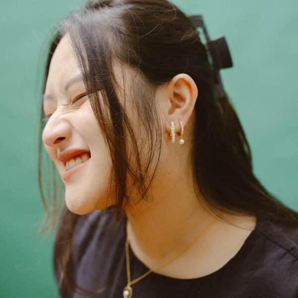 Model wearing black dress and pearls