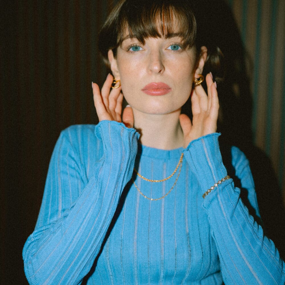 Gold jewellery on a blue top