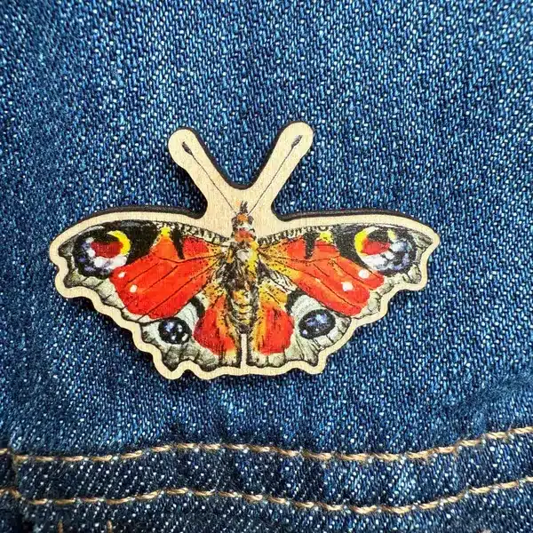Sustainable wooden pin badge with peacock butterfly design