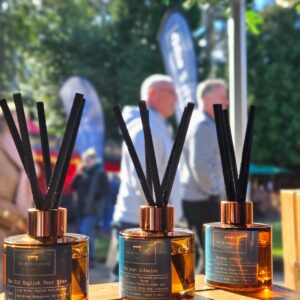 Three glass reed diffuser's on display at an outdoor market