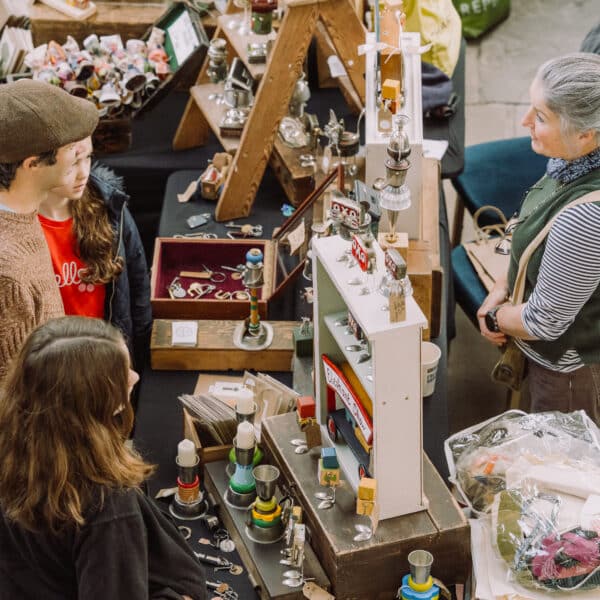 Shoppers talking to a trader at her stall at a So Retro vintage fair