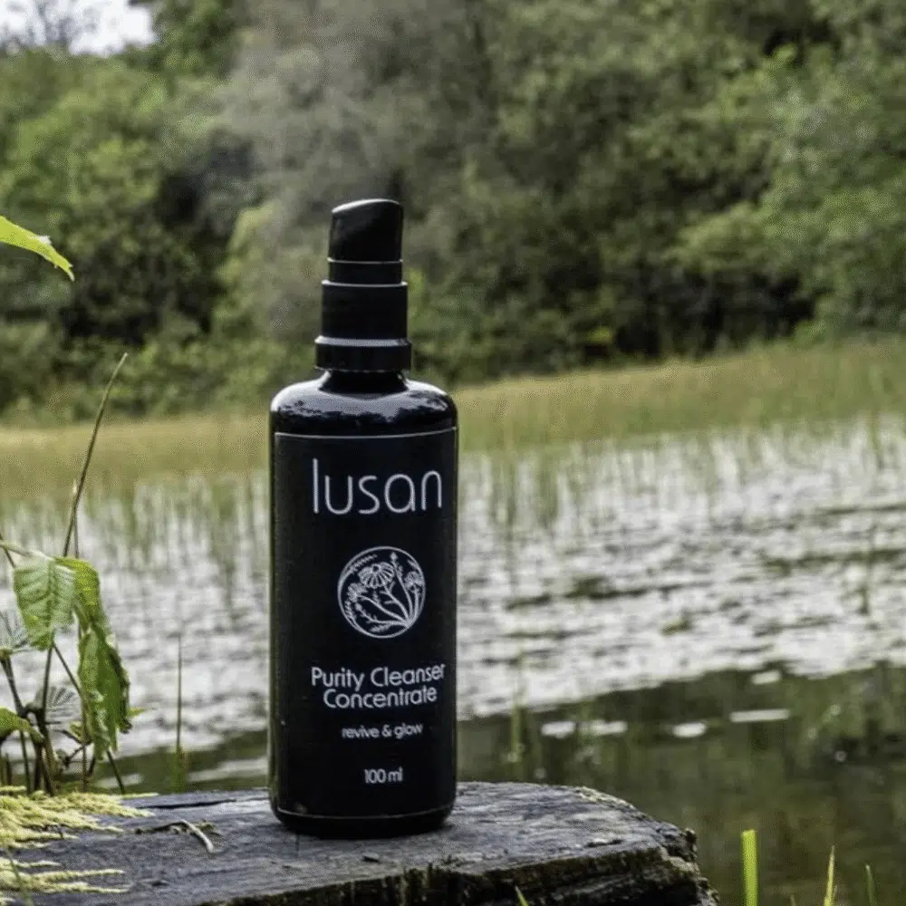 A black coloured bottle containing skincare