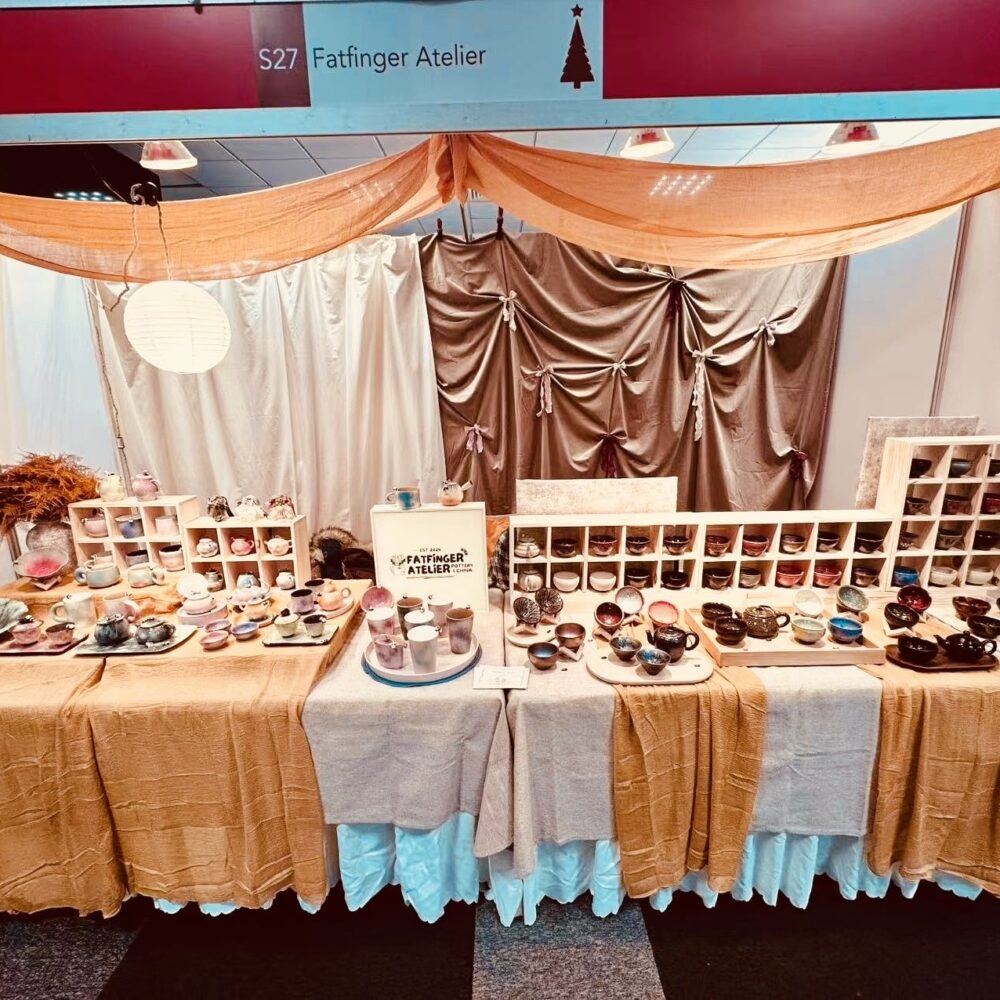 Fatfinger Atelier exhibition stand displaying handmade ceramic tea sets, cups and panda pottery arranged on tables