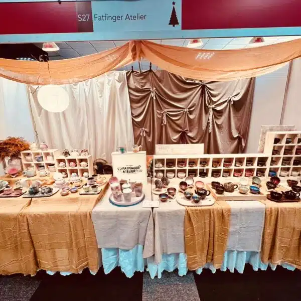 Fatfinger Atelier exhibition stand displaying handmade ceramic tea sets, cups and panda pottery arranged on tables