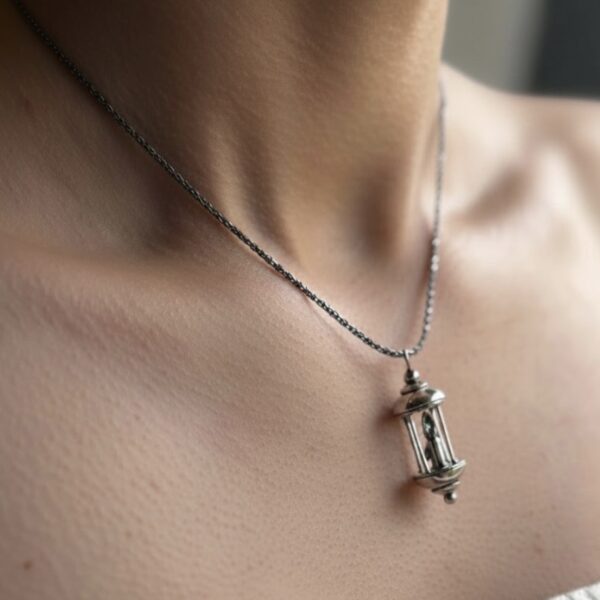 A little lantern pendant made from silver. A candle burns in the centre and a little drip of wax moves down the candle. The light symbolises what is ‘Always Within’ us, even if we lose sight of it sometimes…