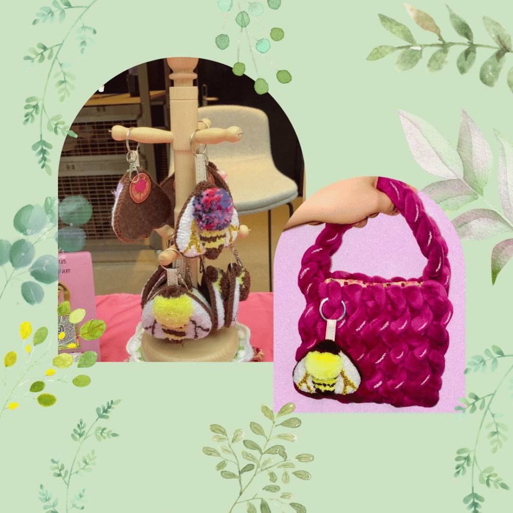 A square collage graphic with a light green background decorated with soft watercolour leaves and vines. Inside two arched frames, the image shows handmade textile crafts. The left arch features a wooden tree-style stand displaying several textured punch needle bee keychains with metal clasps. The right arch displays a hand holding a chunky, braided magenta velvet handbag, showing a fluffy yellow and white punch needle bee keychain clipped to the front handle as a decorative accessory.