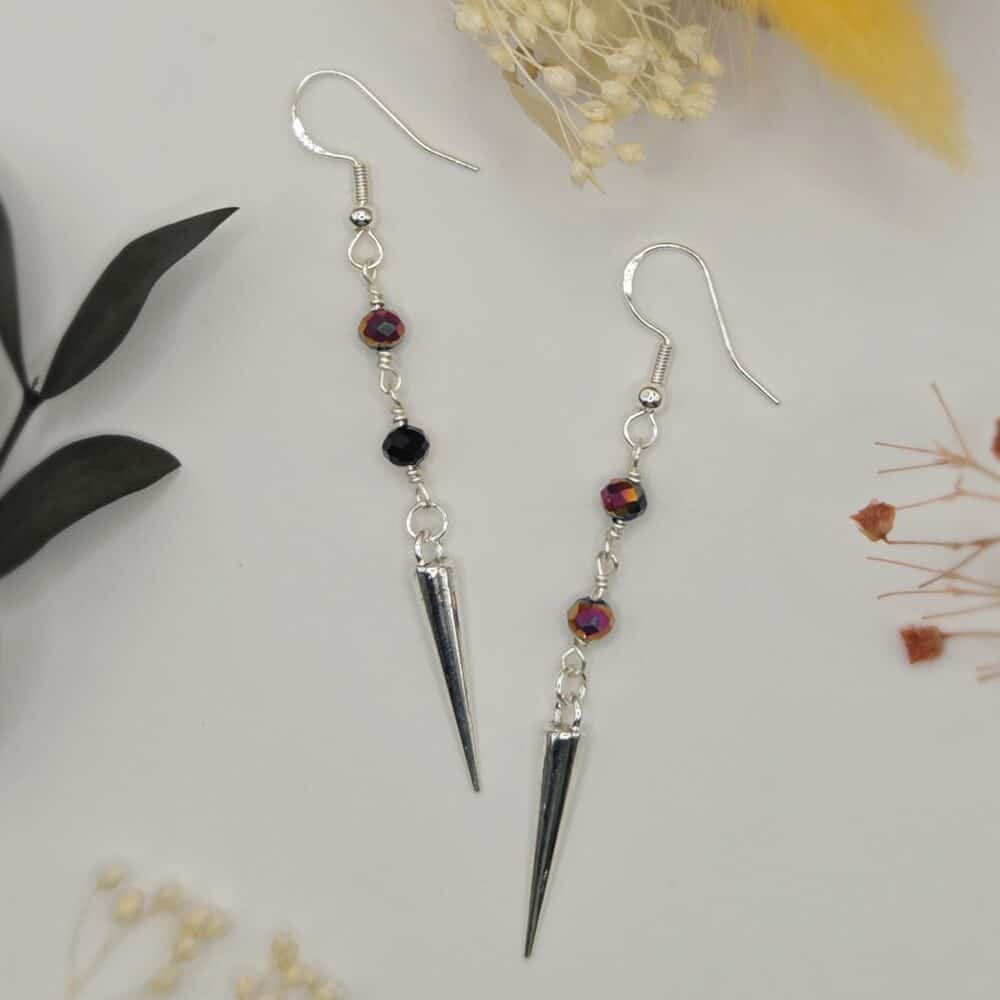 A pair of silver earrings with wire-wrapped black and rainbow round beads, attached to silver spike charms by SunstoneAndFern