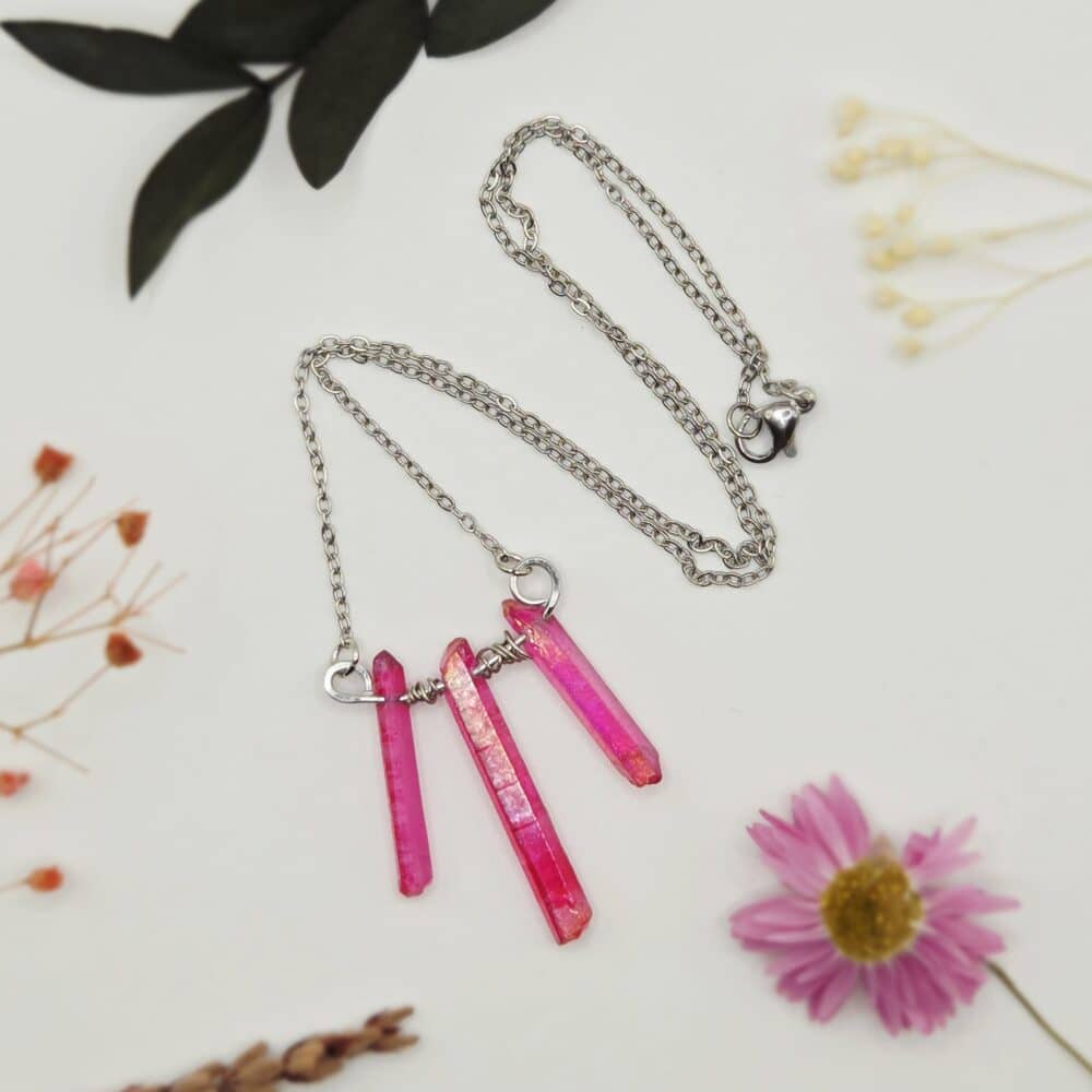 A necklace pendant with three raw pink aura quartz points which are wire-wrapped by SunstoneAndFern